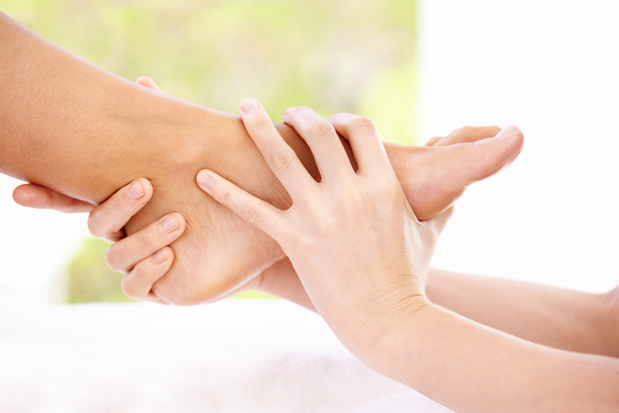 A cropped shot of a massage therapist giving a woman a foot massage